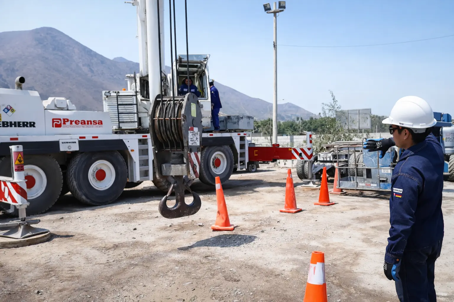 Operador calificado y certificado posando junto a camión grúa articulada en prácticas de ECAX